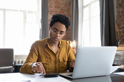 Credit controller reviewing customer accounts and invoices on a laptop