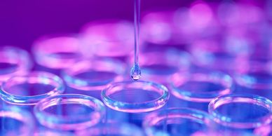 Drop going into beaker symbolizing lab tests, studies, and investigations of root cause medicine.