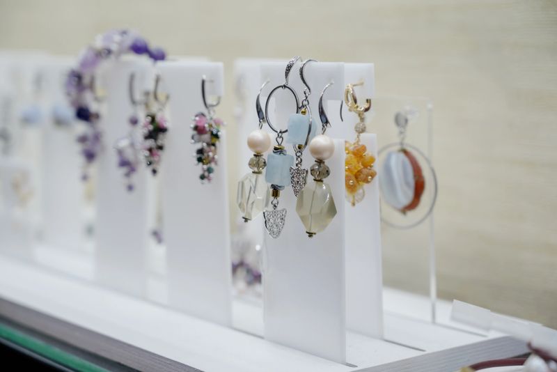 Shop window with necklaces and jewelry. Custome jewelry on display.Variety of colorful necklaces, bracelets, earrings, rings in window of costume jewelry store