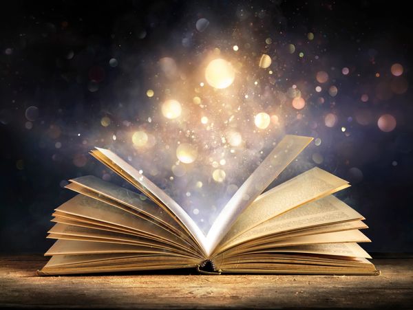 Open book glowing with magical light and imagination