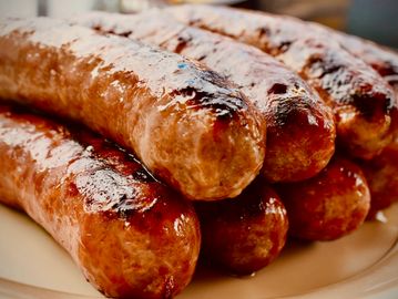 Close-up of grilled sausages with a shiny, glazed surface.