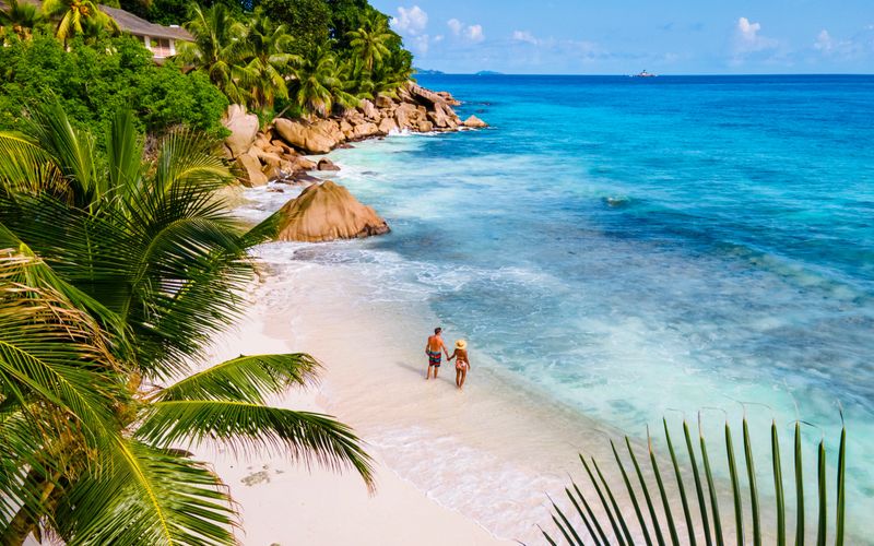 Anse Source d'Argent, La Digue Seychelles, a young couple of men and women on a tropical beach during a luxury vacation in Seychelles. Tropical beach Anse Source d'Argent, La Digue Seychelles
