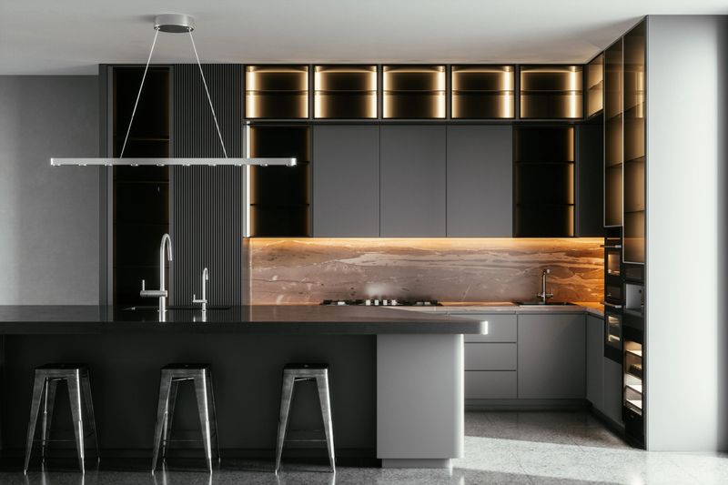 Black / gray modern kitchen interior with island, sink, cabinets, kitchen appliances and marble floor in a new luxury home.