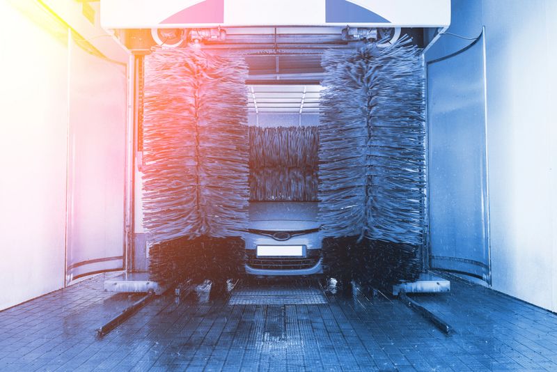 Car washing automatic carwash. Brush washer clean blue auto car on automatic car wash station. Carwash cleaning service