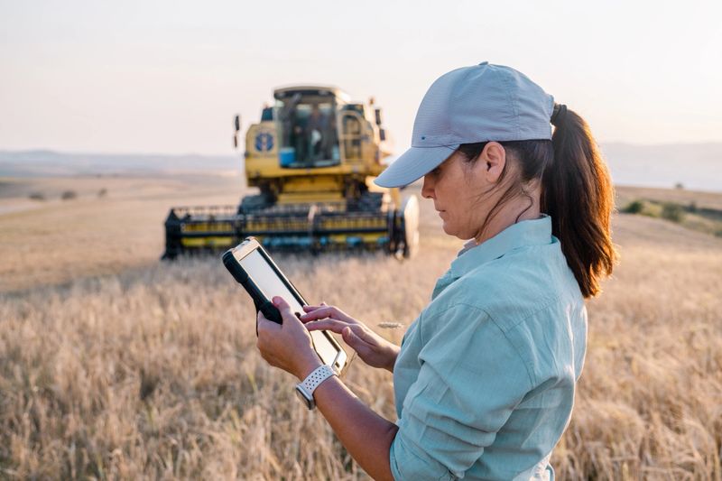 Female Farmer is Holding a Digital Tablet in a Farm Field. Smart Farming
