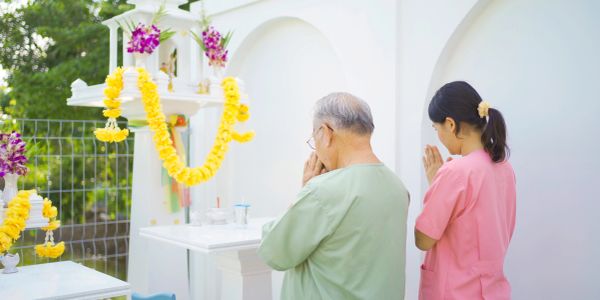 Two people praying at a decorated altar.