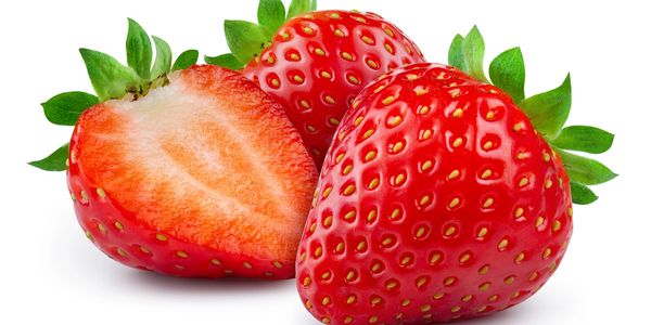 Bright red strawberries with green leaves, one cut in half showing the juicy interior.