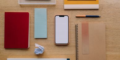 Organized office supplies with a smartphone on a wooden desk.
