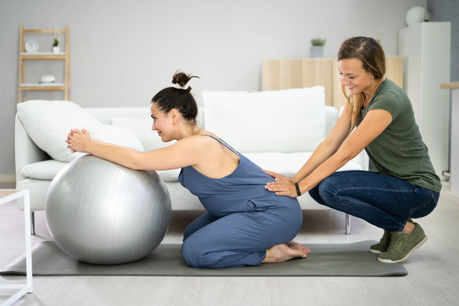 a doula applying counter pressure to a pregnant woman's lower back 