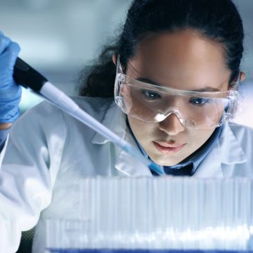 Scientist using a pipette in a lab.