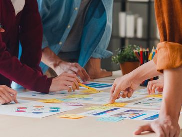 Team collaborating over colorful notes and charts on a table.