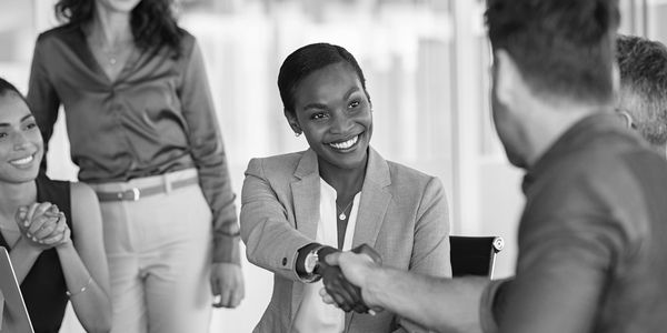 Business handshake with smiles in office.