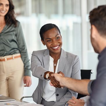 Businesswoman shaking hands with a colleague during a meeting.