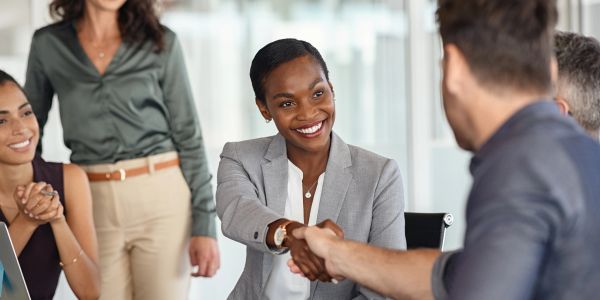 Business handshake with smiles in office.