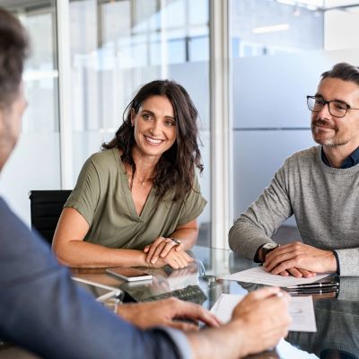Business meeting with three people discussing ideas.