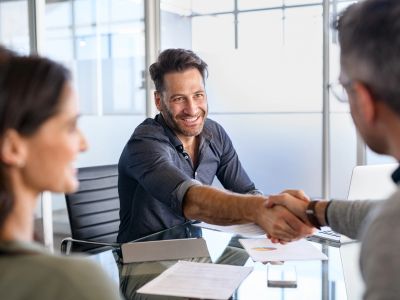 Two men shaking hands during a meeting.