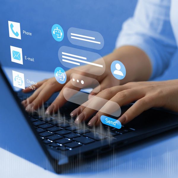 Person interacting with a chatbot interface on a laptop keyboard.