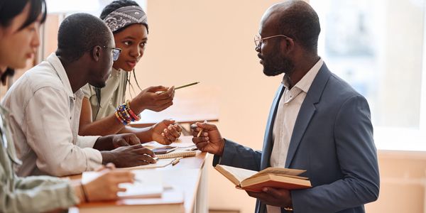 Jeunes adultes noirs et équipe diversifiée engagés dans une initiative communautaire et éducative.