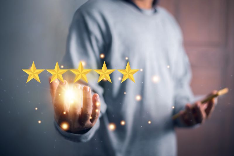 Businessman using hand show the five-star symbol for highest satisfaction, 5-star feedback, reputation and quality, Concept of standardization and quality in products and services.