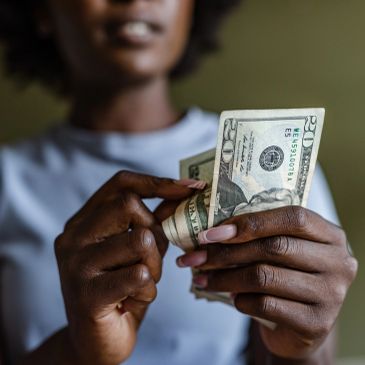 Person counting twenty dollar bills.