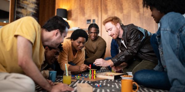 Group of friends playing a board game together indoors.