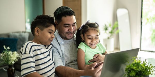 A man and two child looking on the laptop screen
