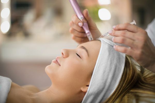 A woman receives a facial injection treatment at a spa.