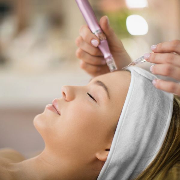 Woman receiving a facial treatment with a skin care device.