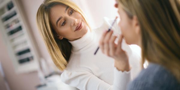 A woman applying makeup on another woman.