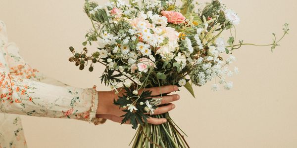 Hand holding a bouquet of wildflowers.