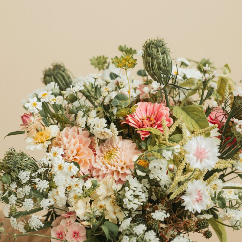 Woman holding bouquet of flowers studio shot pastel