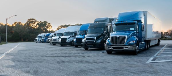 A lineup of semi trucks parked side by side.