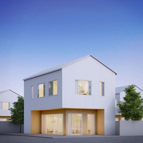 Modern two-story house with white and wood exterior under clear blue sky.