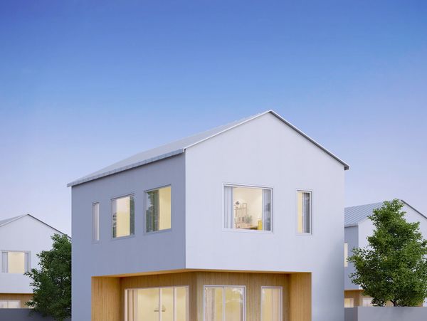 Modern two-story house with white and wood exterior under clear blue sky.