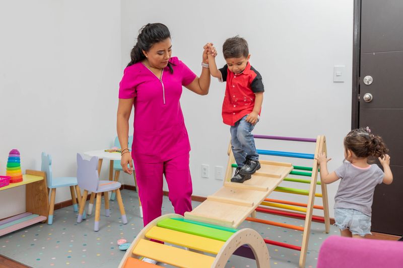 Pediatric doctor giving therapy to a child in the playground of her medical office.