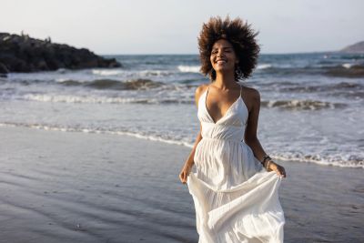 Woman in white dress enjoying the beach.
