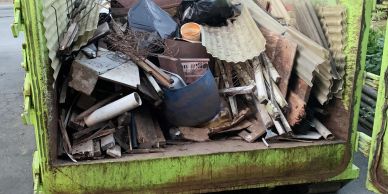 Dumpster filled with construction debris and old materials.