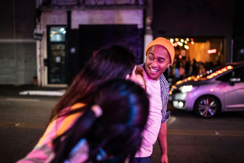 Young man walking in the street with friends at night