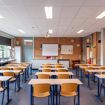 Empty classroom with desks and chairs — School Closure Studies service card describing objective clo