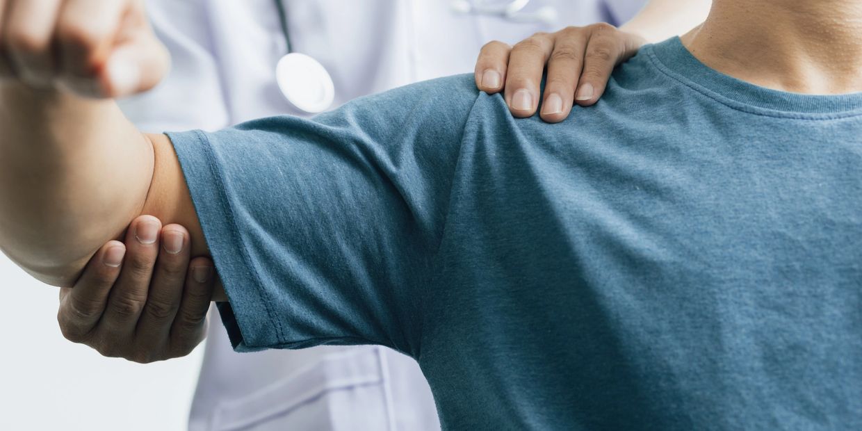 Physical therapist assists patient with arm exercises.