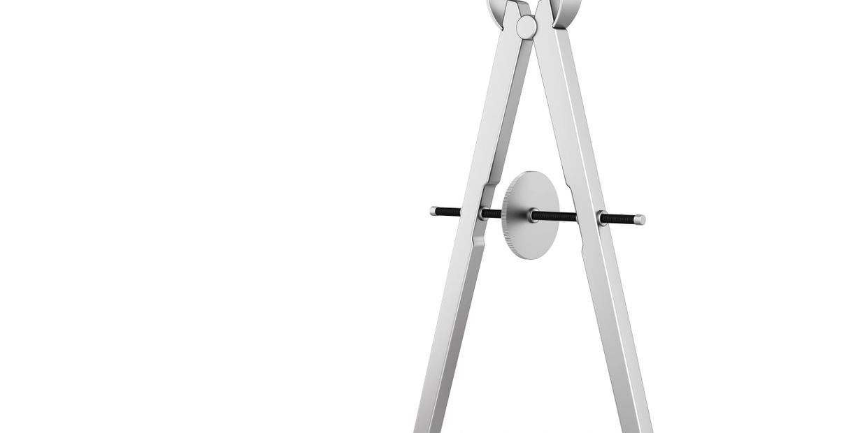 Close-up of a metallic compass tool on a white background.