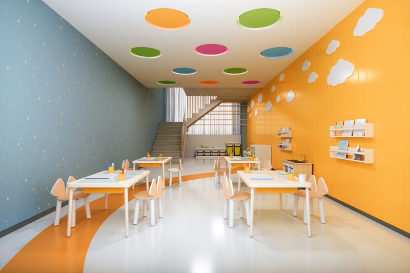 Empty Kindergarten Classroom With Tables, Chairs And Colored Walls