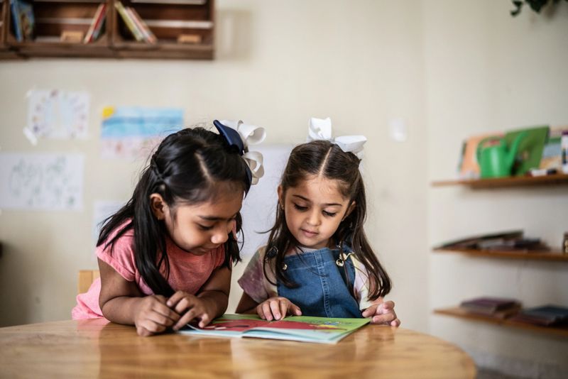 Girls reading book in classroom at school