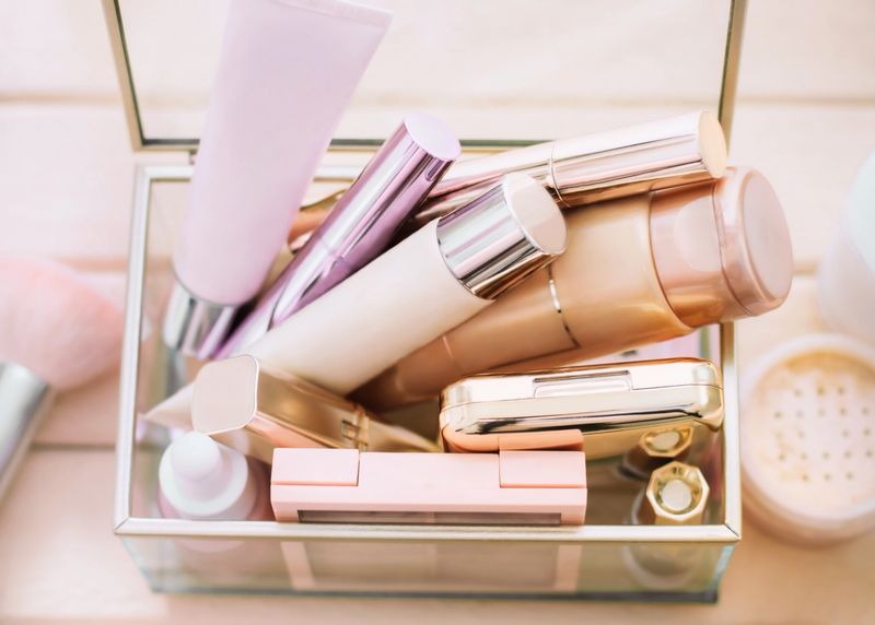 make-up set: foundation, powder, mascara, lipstick in a glass box on the table