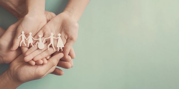 hands holding a paper cut out of people