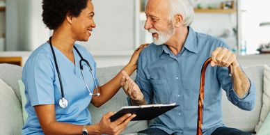 A nurse warmly interacting with an elderly man holding a walking cane.