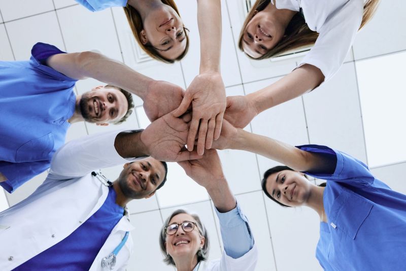 Bottom view of multiethnic medical team putting hands together in circle for success work. Patients health in doctors hands