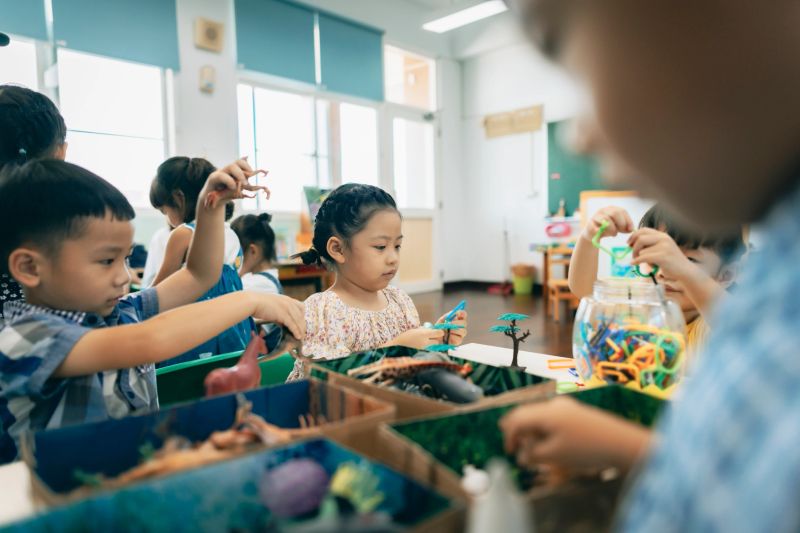 Preschool children playing with teaching aids in classroom