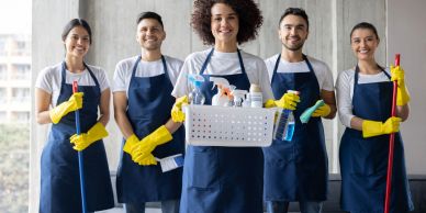 A cleaning team posing with supplies and tools.