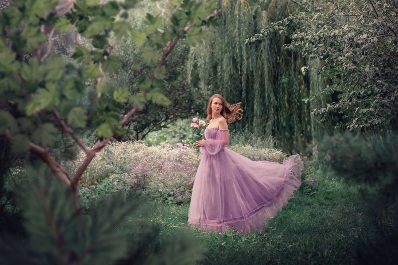 Elegant gown displayed in a whimsical garden setting.